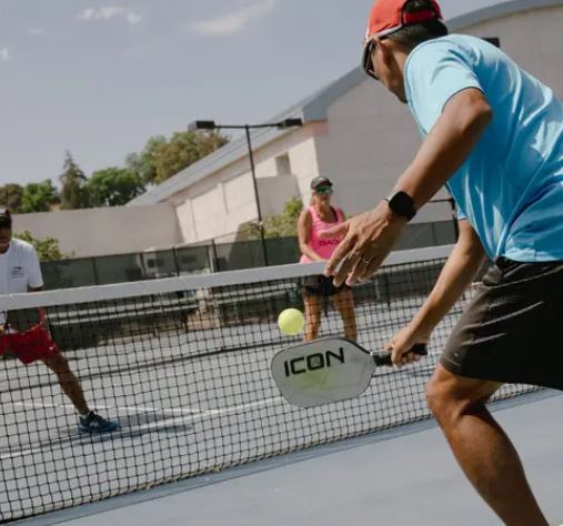 Pickleball player experiencing elbow pain with Dr. Jason Pirozzolo’s prevention tips